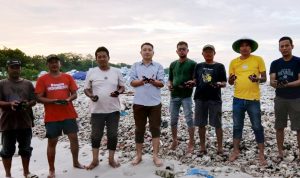 Warga Pandeglang saat memperlihatkan batu bara yang tumpah akibat kapal yang kandas.*//Foto istimewa