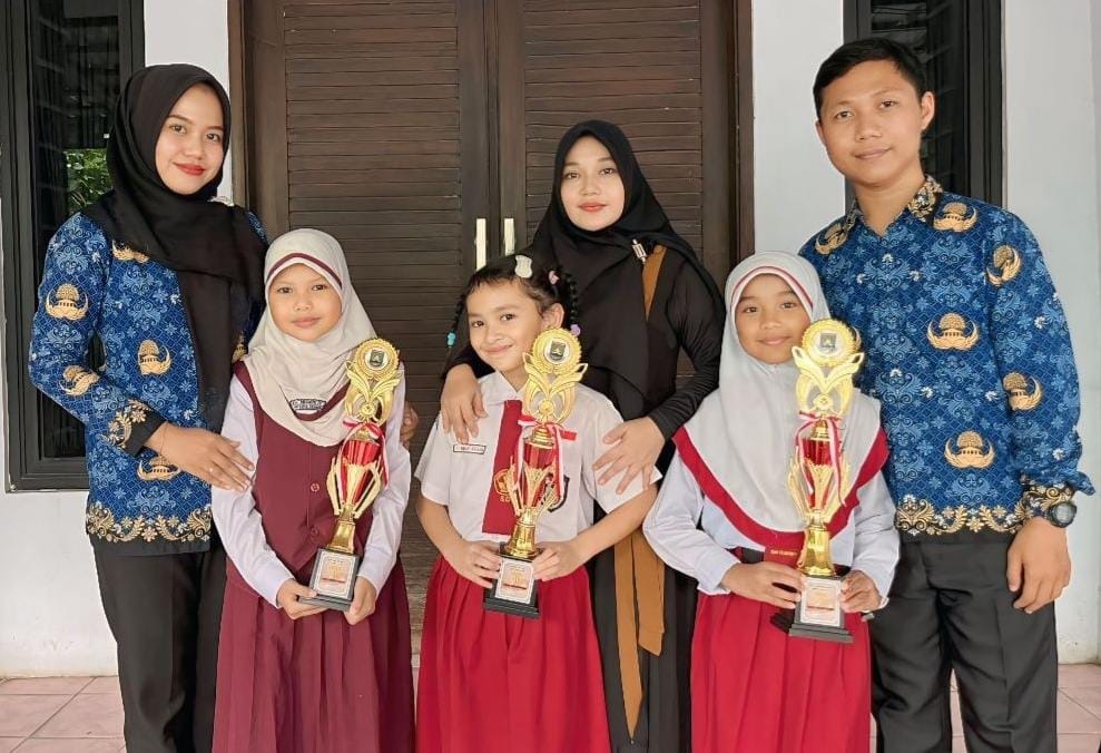 Pelatih dan guru pendamping FLS3N SD Tingkat Kota Cilegon saat foto bersama dengan piala kejuaraan.*//IST