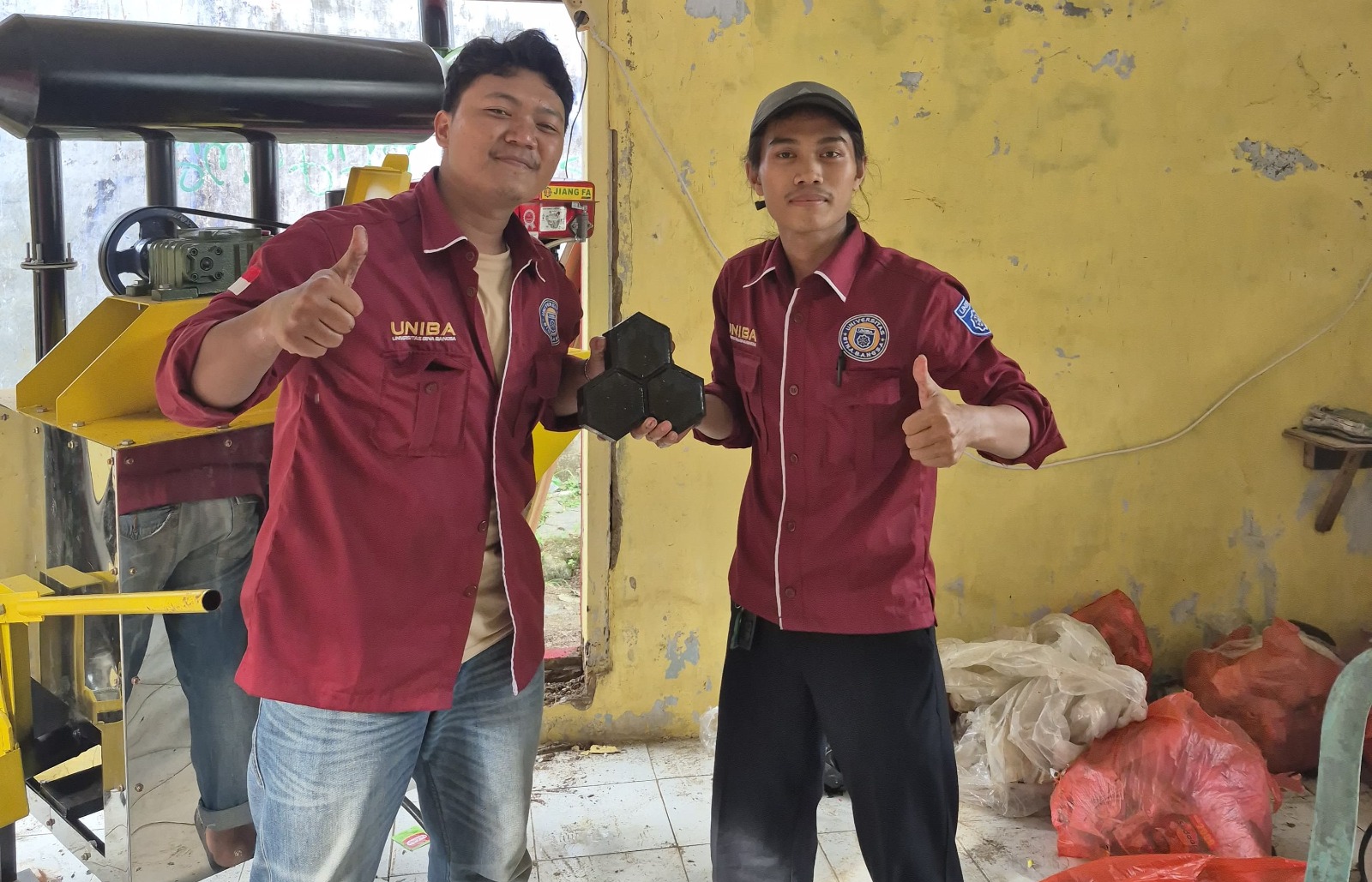 Dua mahasiswa dari Kelompok 46 Kuliah Kerja Mahasiswa (KKM) Universitas Bina Bangsa (UNIBA) memperlihatkan hasil paving block dari limbah sampah.*//Foto istimewa