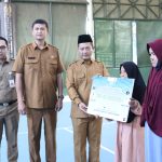Wakil Bupati Serang Muhamad Najib Hamas didampingi Sekda Zaldi Dhuna dan Kepala DPRKP Okey Oktaviana saat menyerahkan secara simbolis bantuan RTLH, di lapangan tenis indoor Pemkab Serang, Senin (1/9/2025).