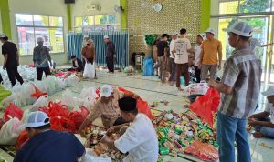 Panitia saat melakukan pembungkusan panjang mulud untuk dibagikan ke warga.*//Foto istimewa