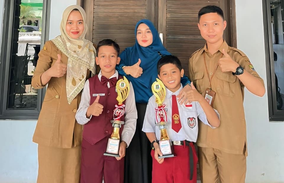 Murid SDN Cilegon 4 dan 01 bersama guru pendamping Isma Atul Fazriyah dan Kiki Trisna Mukti serta pelatih Ferra Hasmawati saat foto bersama dengan trofi kejuaraan lomba.*//Foto istimewa
