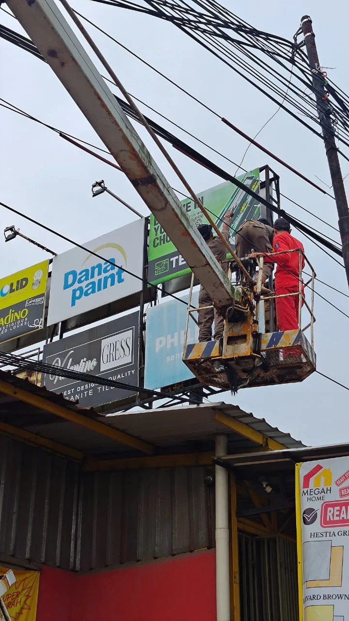 Petugas Satpol PP bersama Bapenda Kabupaten Serang saat melakukan penertiban reklame menunggak pajak .