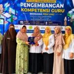 Serah terima plakat simbolis pembukaan kegiatan pengabdian masyarakat, workshop pembuatan buku dan perpustakaan digital dari mahasiswa Magister Pendidikan Dasar UNJ, Erlina, April, Nyi Reni, Nurhasanah, Indri, kepada Korwil Kecamatan Setu Khalis Endah W, SE,M.Tr. A.P.//ISTIMEWA